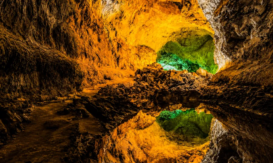 Illuminated volcanic rock formations inside Cueva de los Verdes in Lanzarote